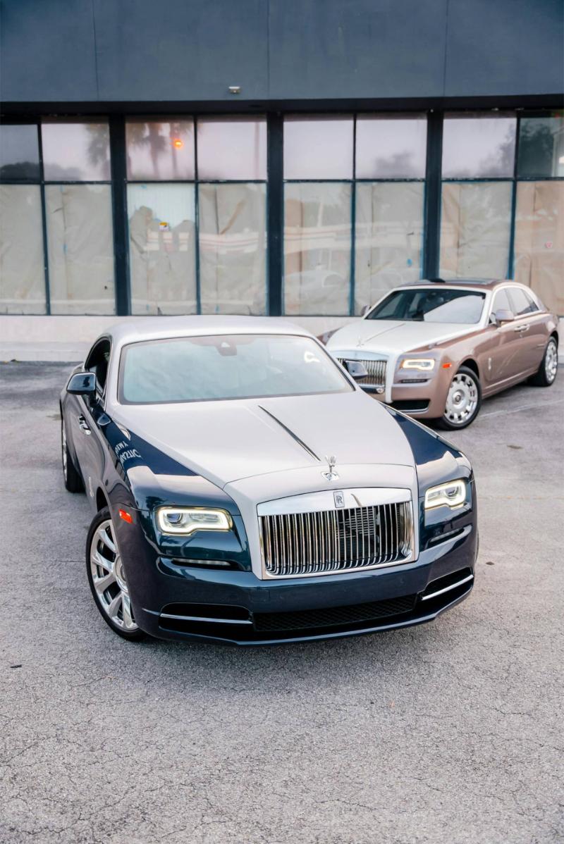 Zwei Rolls-Royce Wraith-Fahrzeuge vor einem modernen Gebäude, das luxuriöses Design präsentiert.
